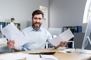 Frustrated and worried businessman looks at bad accounting report