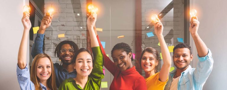 Group of Happy SBIR Grant Winners holding Light Bulbs above their heads