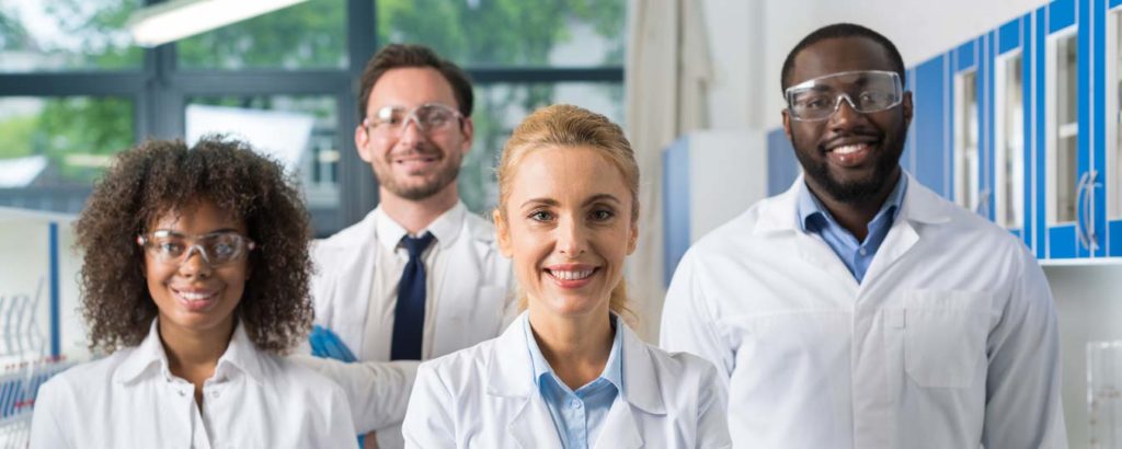4 Happy scientist in lab coats - 2 men and 2 women