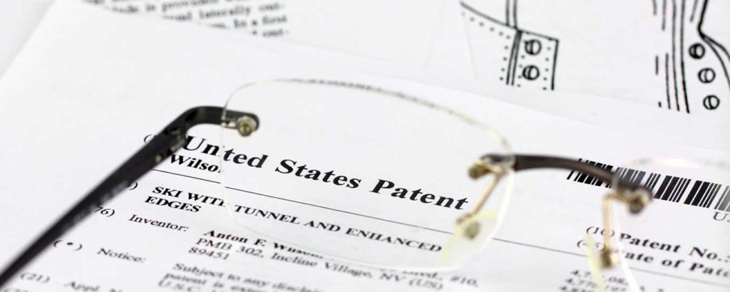 Glasses sitting on paper work for United States Patent for SBIR Data Rights