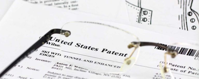 Glasses sitting on paper work for United States Patent for SBIR Data Rights