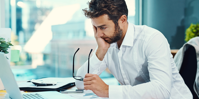 Business owner reviewing financial reports for government contractor accounting and invoicing.